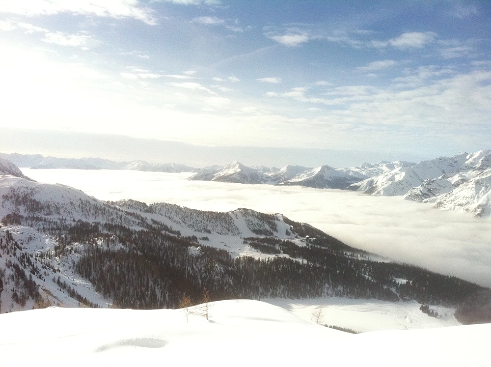 Blick auf die verschneiten Alpen über den Wolken